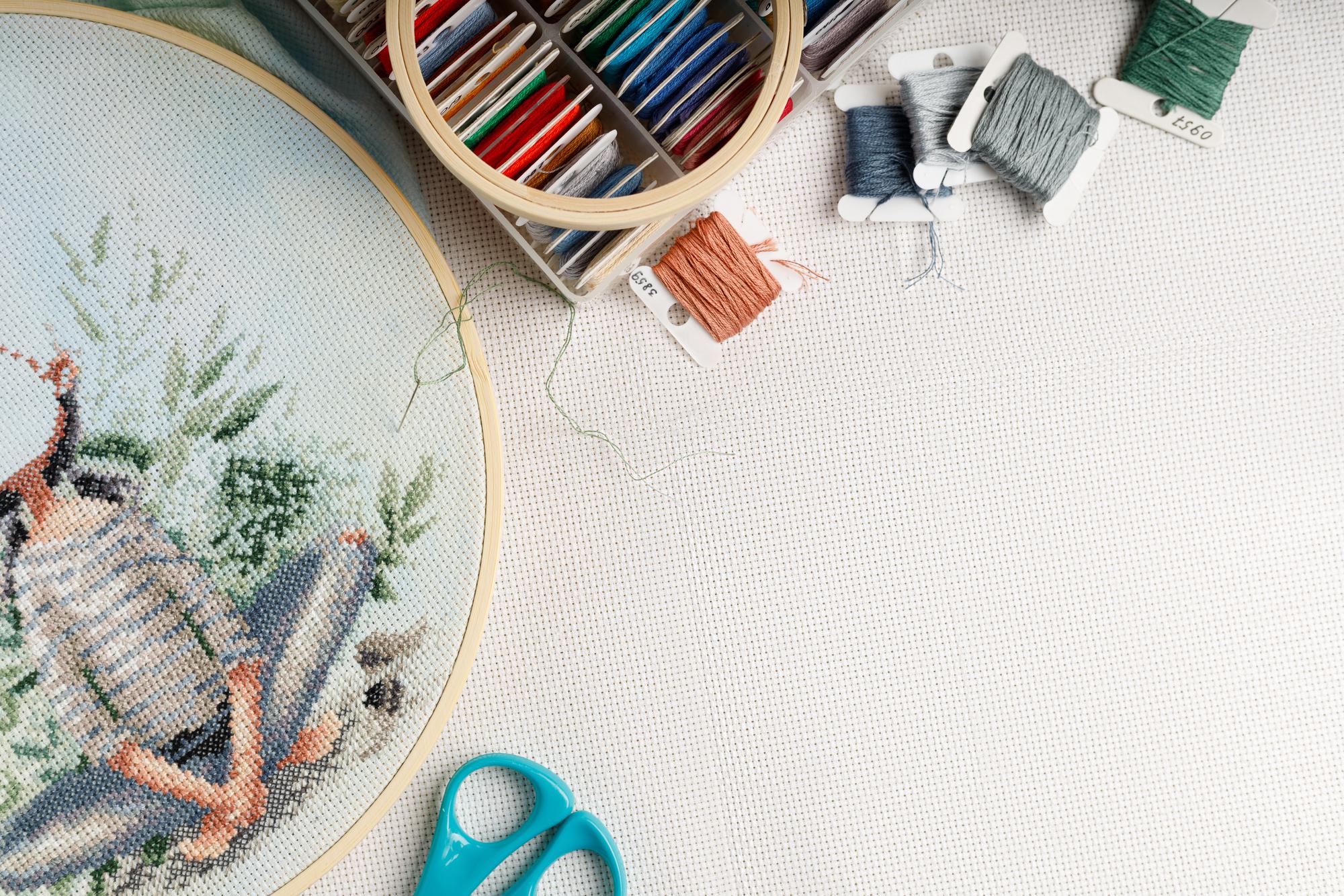 Arbeitsplatz mit Stickrahmen und Garnspulen